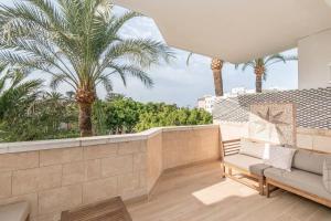 - un balcon avec un canapé et des palmiers dans l'établissement 234 - Puerto Estepona - Kai Alde, à Estepona