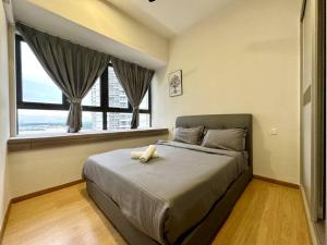 ein Schlafzimmer mit einem großen Bett und einem großen Fenster in der Unterkunft SeaView Danga Bay - Heart of City - by Cowidea in Johor Bahru