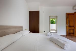 a large white bed with white sheets and towels on it at Villa del Sol by Perle di Puglia in Otranto +39 photos