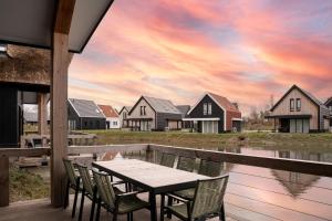 een tafel en stoelen op een terras met huizen bij Dormio Resort Nieuwvliet-Bad in Nieuwvliet