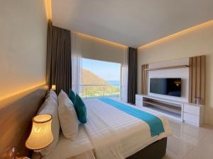 a bedroom with a large bed with a large window at Zasgo Hotel in Labuan Bajo