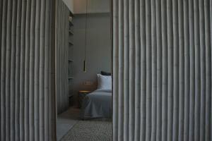 Habitación con 1 cama en una habitación con paredes de bambú. en The Konkret Lombok en Kuta Lombok