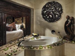 a bathroom with a large tub in a room with a bed at Royal Garden Villas, Luxury Hotel in Adeje