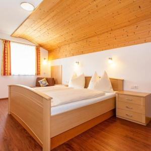 a large bed in a room with a wooden ceiling at Appartement Nr 6 Alpenstern in Wagrain