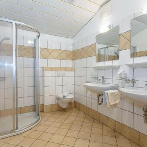 a bathroom with two sinks and a shower and a toilet at Appartement Nr 6 Alpenstern in Wagrain