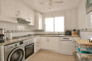 una cocina blanca con lavadora. en Villa Noma, en El Campello