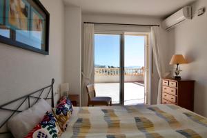 Un dormitorio con una cama y una puerta corrediza de vidrio. en Villa Noma, en El Campello 20 fotos más