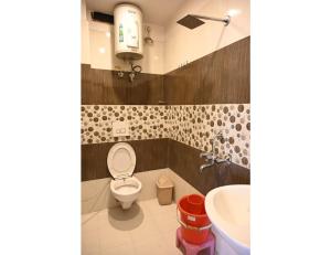 a bathroom with a toilet and a sink at Hotel Arya, Varanasi in Varanasi