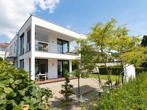 una casa blanca con un jardín delante de ella en Ferienwohnungen Splendid, en Uhldingen-Mühlhofen