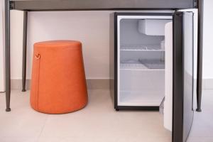 an orange trash can sitting next to an open refrigerator at Le Tartane B&b Guidaloca in Castellammare del Golfo