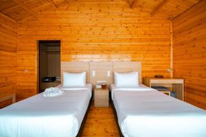 two beds in a room with wooden walls at JSK Mantanani Island Resorts in Mantanani Island 