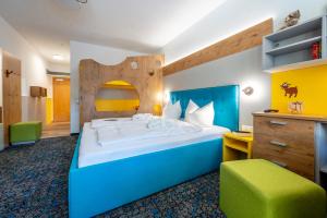 a bedroom with a large bed with a wooden headboard at Familotel Mein Krug in Warmensteinach