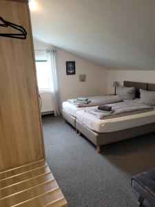 two twin beds in a room with a staircase at Pension Turm in Schönwald