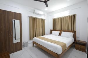 1 dormitorio con 1 cama grande y espejo en INDIGO PALMS en Thiruvananthapuram