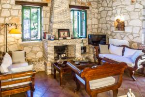 a living room with a couch and a fireplace at Villa Lida Aresti in Agios Leon