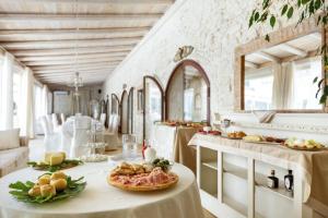 a dining room with a table with food on it at Masseria Cucuruzza Boutique Hotel in Felline