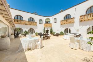 a courtyard with tables and chairs in a building at Masseria Cucuruzza Boutique Hotel in Felline