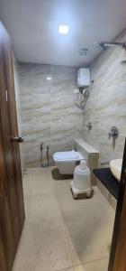 a bathroom with a toilet and two sinks in it at Hotel Sun Shine in Ahmedabad