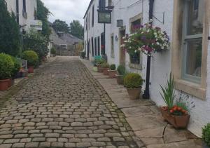 a cobblestone street with potted plants and a building at Cobble View Cottage in Waddington