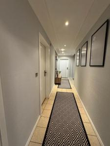 un pasillo con una alfombra blanca y negra en el suelo en Rogge, Ferienhaus, en Fintel
