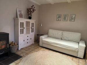 sala de estar con sofá blanco y chimenea en Rogge, Ferienhaus, en Fintel