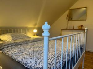 a bedroom with a bed with a blue and white comforter at Rogge, Ferienhaus in Fintel