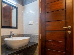 baño con lavabo y puerta de madera en PARKKAVAN TOWERS, en Tiruchchirāppalli