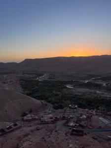 una vista aérea de una ciudad con la puesta de sol en el fondo en Kasbah Tigmi El Janoub, en Aït Ben Haddou