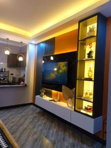 un salon avec une télévision et une étagère dans l'établissement Serene Homes 05, à Kampala