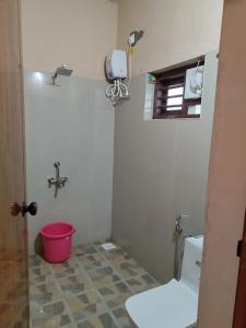 uma casa de banho com um WC e um balde vermelho em antelopewildstay em Kutta