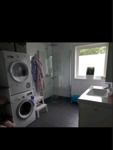 a bathroom with a washing machine and a sink at Hus ved sjøen in Bakken +4 photos