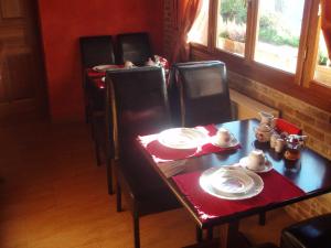 Synikia Mesi TrikalonにあるEnthymio Suitesのダイニングルームテーブル(椅子、皿付)
