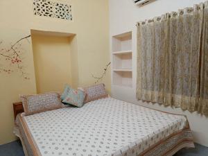 a bedroom with a bed and a window at Haveli Zorawar in Udaipur