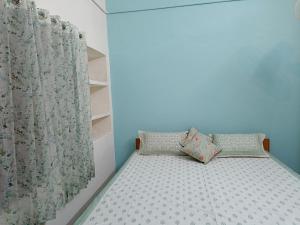 ein kleines Bett mit zwei Kissen in einem Schlafzimmer in der Unterkunft Haveli Zorawar in Udaipur
