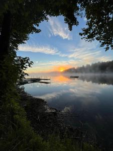 a misty lake with a dock and the sunrise at Elemental Resort in Gwinn