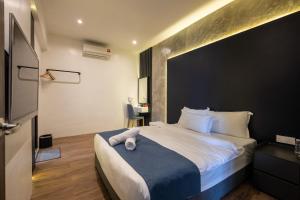 a bedroom with a large bed with a black wall at Boutique Hidden loft in Bukit Mertajam