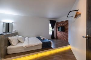 a bedroom with a bed and a brick wall at Boutique Hidden loft in Bukit Mertajam