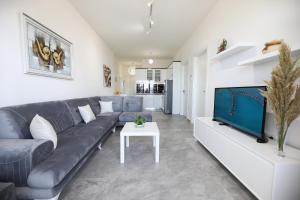 a living room with a couch and a tv at Jimi Apartments in Vlorë