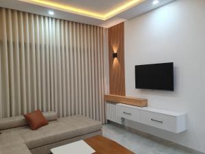 een woonkamer met een bank en een flatscreen-tv bij Comfystay in Hammamet