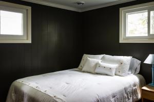 1 Schlafzimmer mit einem weißen Bett und 2 Fenstern in der Unterkunft Elemental Resort in Gwinn