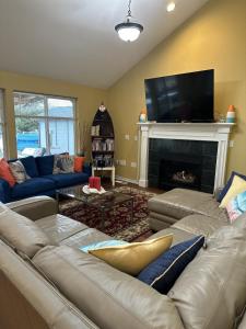 een woonkamer met een bank en een open haard bij Gearhart Lakefront Vacation Rental in Gearhart