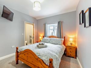 a bedroom with a wooden bed and a window at 2 Bed in Northallerton 90795 in Great Langton