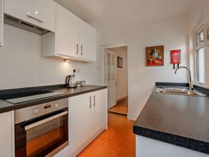 アランデルにある3 Bed in Arundel 90894のキッチン(白いキャビネット、黒いカウンタートップ付)