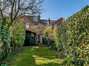 uma casa coberta de hera com uma porta verde e um quintal em 3 Bed in Arundel 90894 em Arundel