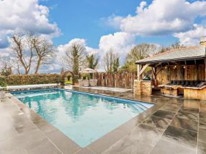 einen Pool in einem Hof mit einem Haus in der Unterkunft 6 Bed in Kings Lynn 90964 in Clenchwarton