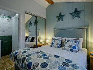 2 Bed in Dunwich 91030 في Westleton: غرفة نوم بسرير ونجمتين على الحائط