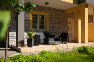 a patio with black chairs and a brick wall at Apartment Gracia 1 in Baška