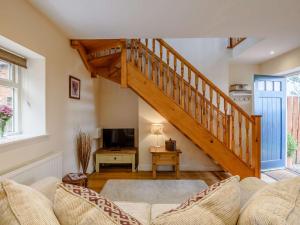 a living room with a staircase and a couch at 1 Bed in Caunton 91130 in Caunton