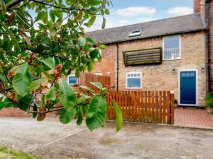 a brick house with a blue door and a fence at 1 Bed in Caunton 91130 in Caunton