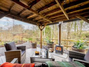 an outdoor patio with a fireplace and chairs and a table at 1 Bed in Loch Lomond 91056 